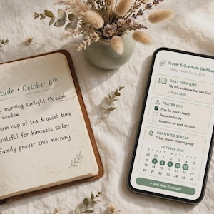 May include: An open notebook with handwritten text titled Gratitude October 6th and a smartphone displaying a Prayer & Gratitude Dashboard app. The screen shows a daily scripture, a prayer list, and a gratitude streak calendar for October 2025.
