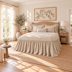 May include: A beige bedspread with a ruffled skirt, featuring multiple pillows including a rectangular lumbar pillow, placed on a wooden bed frame with a cane headboard, flanked by two wooden nightstands with lamps.