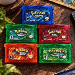 May include: A collection of five Game Boy Advance video game cartridges including Pokémon Sapphire, Emerald, Ruby, FireRed, and LeafGreen versions. Each translucent plastic cartridge features a colorful label with the game title and character art.