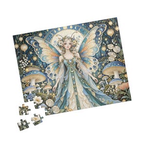 May include: A jigsaw puzzle featuring a central fairy figure with large butterfly wings, wearing a blue and white gown. The scene includes blue mushrooms, glowing lanterns, and floral elements. Four loose puzzle pieces are shown separately.