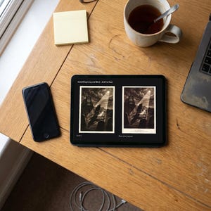 以下が含まれることがあります： Something Long and Black - draft to finalというタイトルのデジタル画像を表示する黒いタブレット。月明かりの下、墓地に立つ暗い影のイラストが2つ並んでおり、それぞれDraft C、Final print, signedとラベル付けされている。