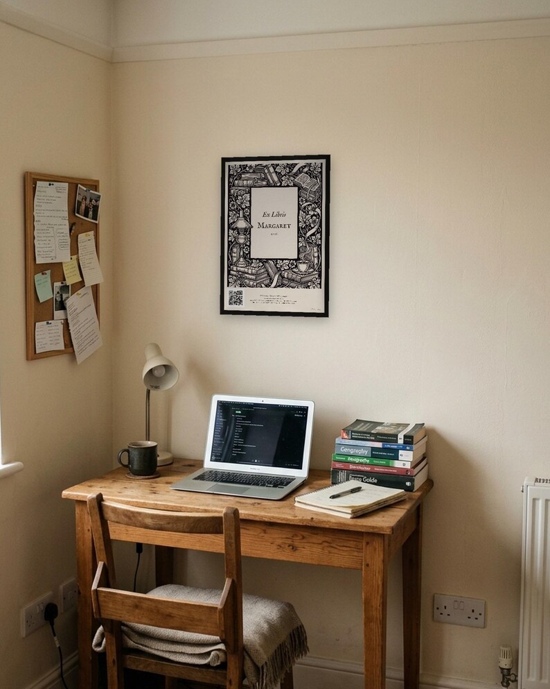 Personalised ex libris bookplate print in engraved ink on cream: a border of stacked books, a reading lamp and a cup of tea, with Ex Libris above and a mum's name and a year set in the centre.