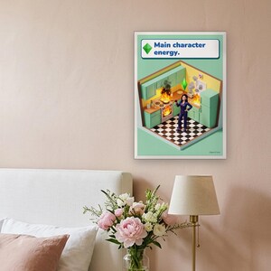 Main character energy funny kitchen print in bright life-sim game style: a calm woman in navy pyjamas holds a glass of red wine while her mint and lemon kitchen burns around her. Shown framed in black, white or natural oak and unframed, with behind-the-scenes shots.