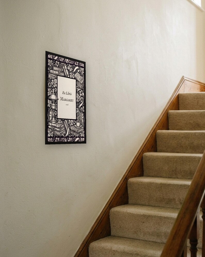 Personalised ex libris bookplate print in engraved ink on cream: a border of stacked books, a reading lamp and a cup of tea, with Ex Libris above and a mum's name and a year set in the centre.