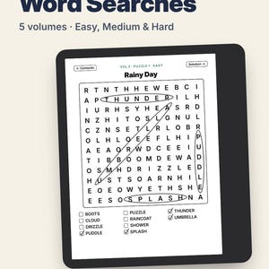 May include: A digital e-reader displaying a word search puzzle titled Rainy Day. The screen shows a grid of letters with circled words, a list of terms including Puddle, Thunder, and Umbrella, and navigation buttons. The text reads 500 Large Print Word Searches.