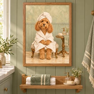 Puede incluir: Una impresión artística enmarcada que muestra a un perro de color marrón dorado con una bata de baño blanca de felpa y una toalla a juego en la cabeza, sentado en un taburete pequeño en un baño con una mesa auxiliar.