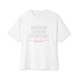 May include: A white short-sleeve t-shirt featuring the text MINIMUM PAYMENT ENTHUSIAST in a grey outlined font, followed by a thin red horizontal line and the text NET WORTHLESS in a smaller red font centered on the chest.