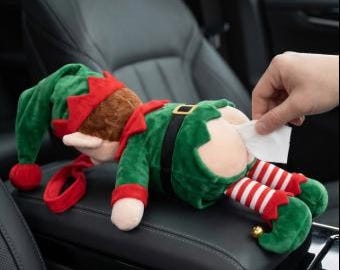 May include: A plush elf doll wearing a green and red outfit with a pointed hat and striped leggings. The doll is designed as a tissue dispenser, with a white tissue being pulled from the back of the elf's pants. The figure features soft fabric textures, a black belt with a gold buckle, and small gold bells on the feet.