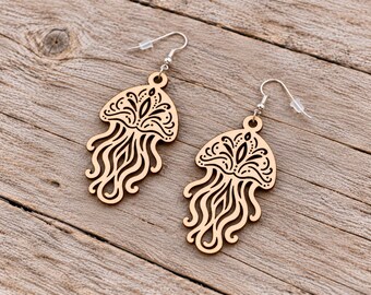 May include: A pair of laser-cut wooden earrings shaped like jellyfish. Each earring features intricate, symmetrical black etched patterns on the bell and long, flowing, cut-out tentacles. They are attached to silver-toned metal fishhook wires.