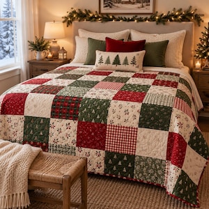 Puede incluir: Una colcha de patchwork con un patrón repetitivo de cuadrados rojos, verdes y crema con estampados navideños que incluyen pinos, flores de pascua y cuadros vichy, sobre una cama con almohadas a juego y un cojín lumbar.