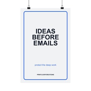 Op de afbeelding: Een verticale witte poster met een blauwe rand, opgehangen aan twee zwarte klemmen. De tekst luidt IDEAS BEFORE EMAILS in grote zwarte letters, gevolgd door de kleinere blauwe tekst protect the deep work en de zwarte tekst PRINTLOOPCREATIONS.