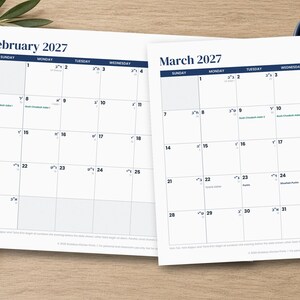 Op de afbeelding: Twee witte papieren kalenderpagina's voor februari 2027 en maart 2027. Elke pagina heeft een rasterindeling met donkerblauwe koppen voor de maand en de dagen van de week. De data bevatten kleine Hebreeuwse tekst en specifieke notities in zwart.