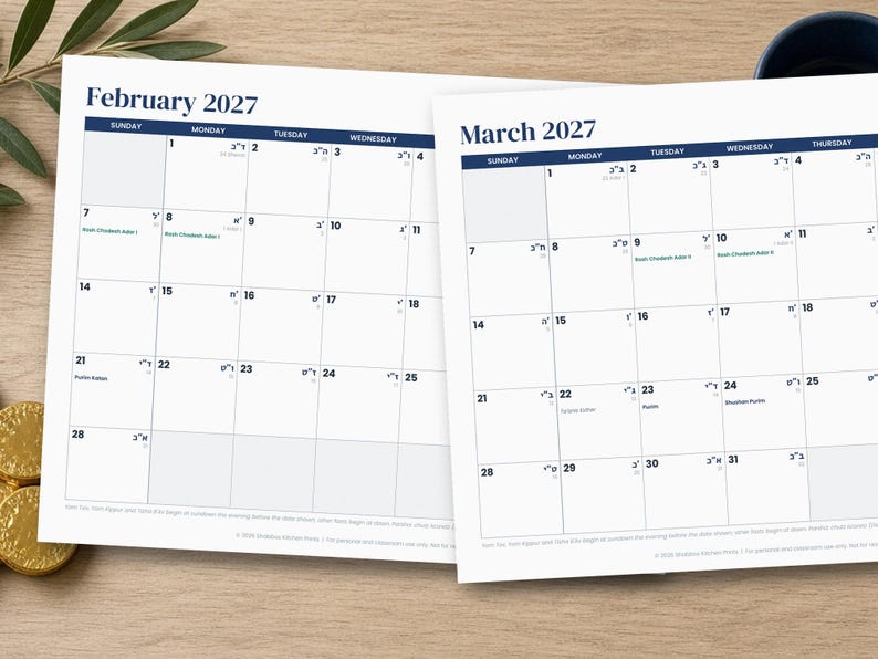 Op de afbeelding: Twee witte papieren kalenderpagina's voor februari 2027 en maart 2027. Elke pagina heeft een rasterindeling met donkerblauwe koppen voor de maand en de dagen van de week. De data bevatten kleine Hebreeuwse tekst en specifieke notities in zwart.