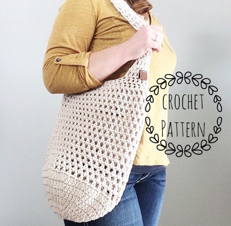 K&ouml;nnte beinhalten: Eine wei&szlig;e H&auml;kel-Tragetasche mit einem braunen Lederriemen. Die Tasche wird von einer Person getragen, die ein gelbes Shirt und eine blaue Jeans tr&auml;gt. Der Text "CROCHET PATTERN" ist in einem Kreis um die Tasche geschrieben.