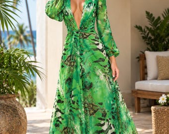 May include: A floor-length green dress featuring a deep V-neckline, long sleeves with gathered cuffs, and a vibrant abstract print in shades of green, black, and white. The garment has a cinched waist and a flowing, full-length skirt.