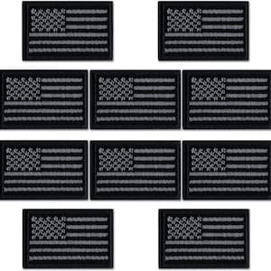 May include: Ten black embroidered American flag patches with a gray outline. The flags are approximately 2 inches by 3 inches.