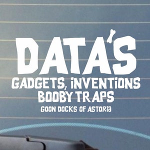 May include: White vinyl sticker with the text "DATA'S GADGETS, INVENTIONS BOOBY TRAPS GOON DOCKS OF ASTORIA" in a bold, blocky font.