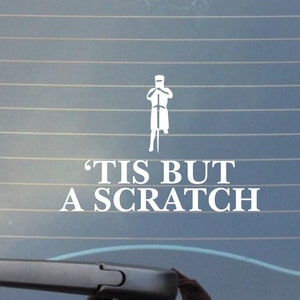 May include: White vinyl sticker with a cartoon knight and the text 'Tis but a scratch'.