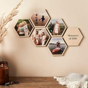 May include: A set of hexagonal wooden photo tiles mounted on a wall, each displaying a family photograph. One tile features the text "Memories of 2020". The arrangement creates a unique display of personal memories, perfect for home decoration.