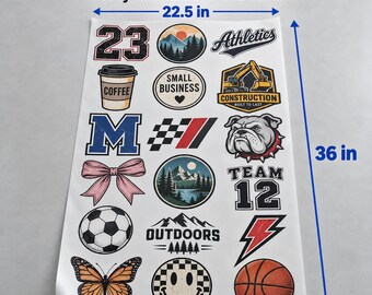 May include: A 22.5 inch by 36 inch gang sheet of ready to press DTF transfers featuring various graphic designs including a coffee cup, a construction vehicle, a bulldog, a soccer ball, a basketball, a butterfly, and text elements.