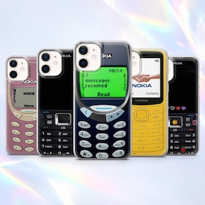 May include: Five clear smartphone cases featuring graphic prints of vintage Nokia mobile phones in pink, black, dark blue, yellow, and black with heart and flower icons. Each case displays a numeric keypad and a screen with text.