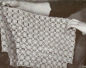 May include: A white crocheted doily with a square pattern. The doily is being held by a person's hands.