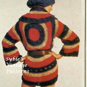 May include: A crochet dress with a red, blue, and beige color scheme. The dress has a round, crocheted design on the front and a belt. The dress is being modeled by a person wearing a blue headscarf.