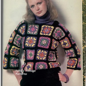 Könnte beinhalten: Ein Vintage-Strickpullover mit einem mehrfarbigen quadratischen Muster. Der Pullover ist schwarz mit Quadraten in Pink, Grün, Gelb und Lila. Das Model trägt den Pullover mit einer schwarzen Hose und einem lila Rollkragenpullover.