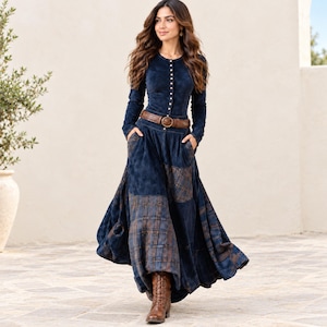 Könnte beinhalten: Ein langärmeliges marineblaues Kleid mit geknöpftem Oberteil, einem braunen Ledergürtel in der Taille und einem bodenlangen Rock mit integrierten braunen Karostoff-Einsätzen. Das Kleid verfügt über Seitentaschen und wird mit braunen Schnürstiefeln kombiniert.