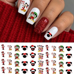 May include: A sheet of Christmas-themed nail decals featuring Mickey and Minnie Mouse in various holiday outfits, including candy canes, wreaths, and Santa hats, alongside a set of manicured nails displaying these designs on white polish.