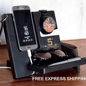May include: Black wooden organiser with a phone stand, watch holder, sunglasses holder, and a pen holder. The organiser has a 5th Anniversary inscription.