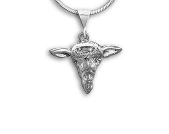 May include: A silver-colored pendant necklace featuring a detailed bull's head pendant. The pendant is suspended from a thin, silver chain. The bull's head has prominent horns and facial features, showcasing a textured design. The necklace is set against a white background.