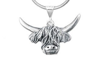 May include: A silver-toned pendant necklace featuring a Highland cow design. The pendant showcases the cow's head with detailed horns and shaggy fur. The necklace has a delicate chain, perfect for everyday wear.