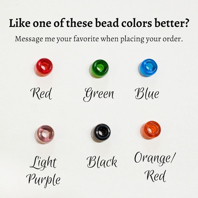 May include: Six round beads in different colours: red, green, blue, light purple, black, and orange/red. The text "Like one of these bead colours better? Message me your favourite when placing your order." is above the beads.