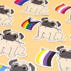 Może przedstawiać: Zestaw dziewięciu naklejek przedstawiających kreskówkowego mopsa trzymającego różne flagi dumy, w tym flagi transpłciowe, biseksualne, lesbijskie, gejowskie, panseksualne, aseksualne, genderqueer i niebinarnych.
