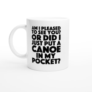 May include: White ceramic coffee mug with black text that reads "Am I pleased to see you? Or did I just put a canoe in my pocket?"