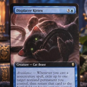 May include: A Magic: The Gathering trading card titled Displacer Kitten, featuring a dark, furry creature with glowing green eyes. The card text includes the name, mana cost, creature type Cat Beast, the Avoidance ability, and power/toughness 2/2.