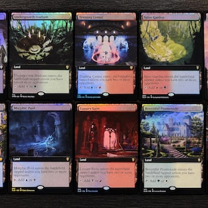 May include: A collection of ten Magic: The Gathering land cards arranged in two rows. Each card features borderless fantasy art, including Vault of Champions, Undergrowth Stadium, Training Center, Spire Garden, Sea of Clouds, Rejuvenating Springs, Morphic Pool, Luxury Suite, Bountiful Promenade, and Spectator Seating.