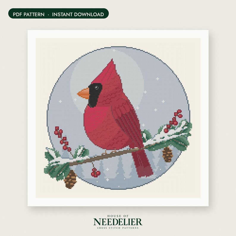 May include: A cross stitch pattern featuring a red cardinal bird perched on a snowy pine branch with red berries and pinecones, set against a circular light blue background with white stars and the text PDF PATTERN INSTANT DOWNLOAD.