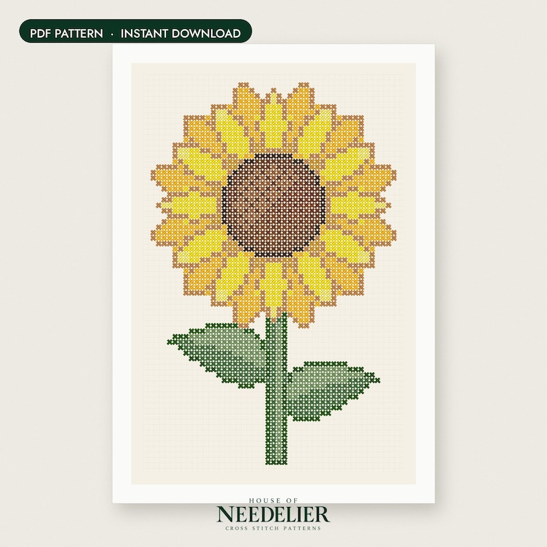 May include: A cross stitch pattern featuring a sunflower with a brown center and yellow petals, accompanied by a green stem and two leaves. The design is set against a light cream grid background. Text at the top reads PDF PATTERN - INSTANT DOWNLOAD.