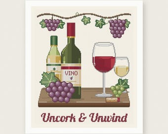 May include: A cross stitch pattern featuring a wine bottle labeled VINO, a white wine bottle, two glasses of wine, purple and green grapes, and a cork on a wooden surface. The text reads Uncork & Unwind in a dark red font on a cream background.