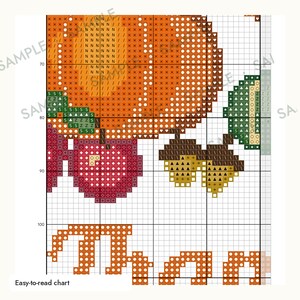 May include: A cross-stitch pattern chart featuring a large orange pumpkin, a red apple, green leaves, and two brown acorns. The grid-based design includes symbols for color placement and the partial orange text "Than" at the bottom of the page.