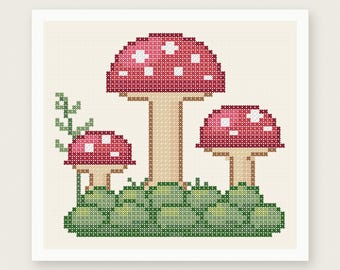 May include: A cross stitch pattern featuring three red mushrooms with white spots on a green mossy base, with a small green vine on the left. The design includes the text PDF PATTERN INSTANT DOWNLOAD and HOUSE OF NEEDELIER CROSS STITCH PATTERNS.