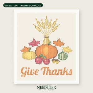 May include: A cross stitch pattern featuring a central orange pumpkin, a yellow pumpkin, a green striped gourd, red apples, acorns, and autumn leaves. Above the produce is a bundle of wheat stalks. The text "Give Thanks" is in orange below.