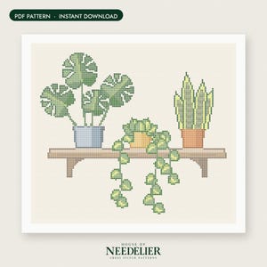 May include: A cross stitch pattern featuring three potted plants on a wooden shelf. The plants include a monstera in a blue pot, a trailing plant in a yellow pot, and a snake plant in a terracotta pot. Text reads PDF PATTERN INSTANT DOWNLOAD.