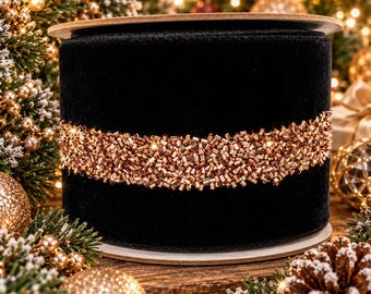May include: A wide spool of black velvet ribbon featuring a central horizontal band of shimmering copper-colored glass beads. The ribbon is wrapped around a circular cardboard core, displaying a dense, textured surface of metallic beadwork.