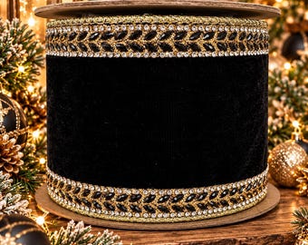 May include: A spool of black velvet ribbon featuring decorative borders on the top and bottom edges. The borders consist of a gold metallic base, a row of small clear rhinestones, and a central pattern of black marquise-shaped crystals.