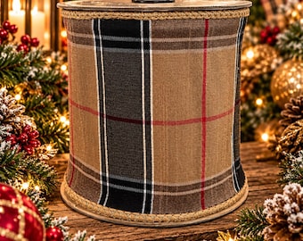 May include: A spool of wired ribbon featuring a plaid pattern in shades of tan, black, and white with thin red accent lines. The ribbon has a textured fabric appearance and is finished with a braided tan trim along the top and bottom edges.