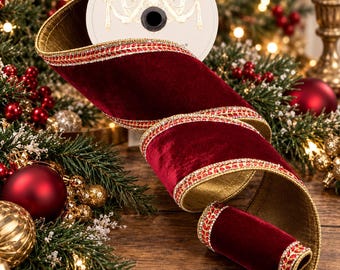 May include: A spool of deep red velvet ribbon featuring a gold metallic backing and decorative edges with a repeating pattern of small red and gold beads. The ribbon is coiled and displayed with a white circular label on the top spool.