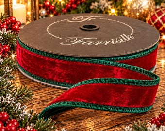 May include: A spool of deep red velvet ribbon featuring dark green velvet edges. The spool is labeled with the text Farrisilk in a white script font. The ribbon is thick and textured, displaying a rich, soft pile on the surface of the fabric.